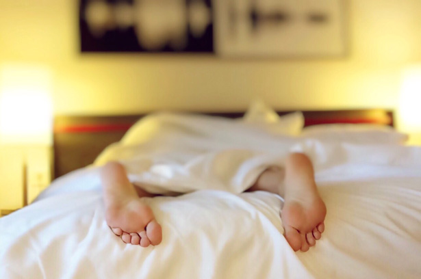 Person in a bed with feet out sleeping after sleep apnea treatment in Detroit